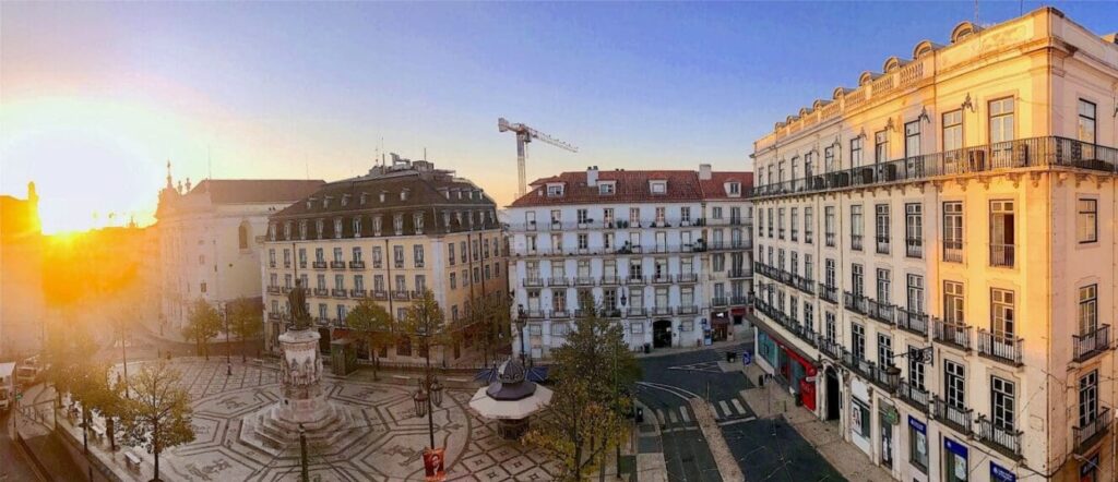 Luis de Camoes Square at sunrise as the warm light bathes the nearby buildings in this loverly square in Lisbon Portugal