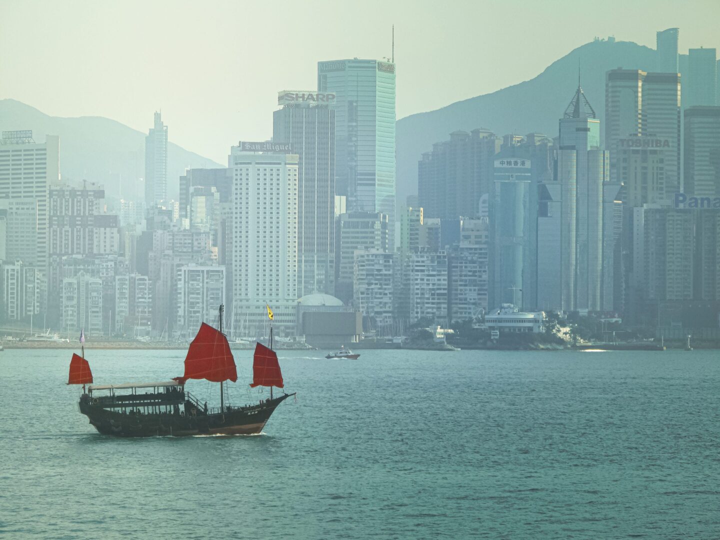 Sampan sailing in Victoria Harbor with Hong Kong, China skyline in the background