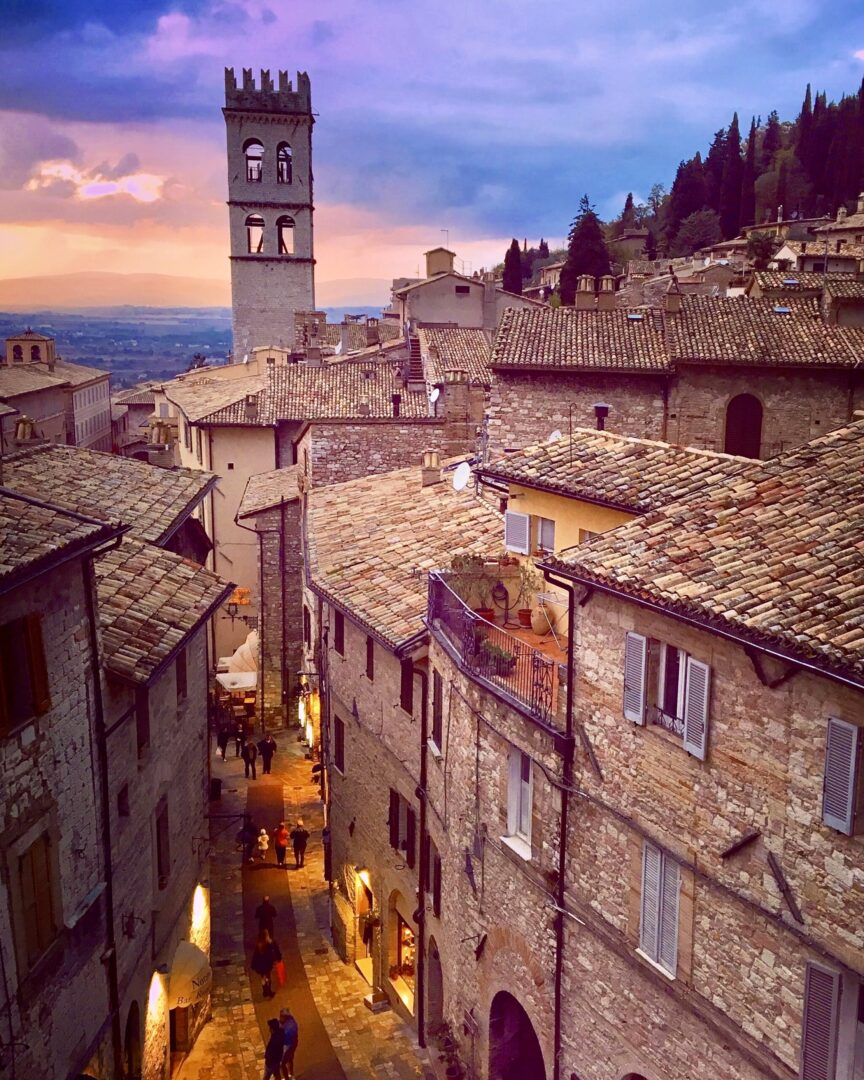 Autumn sunset photo of Popolo Tower and Piazza del Comune in Assisi, Italy