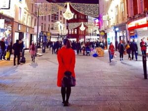 Grafton street pedestrian walking mall at night time lit up by all the Christmas lights and decorations wishing you Nollaig Shona Duit during the festive season