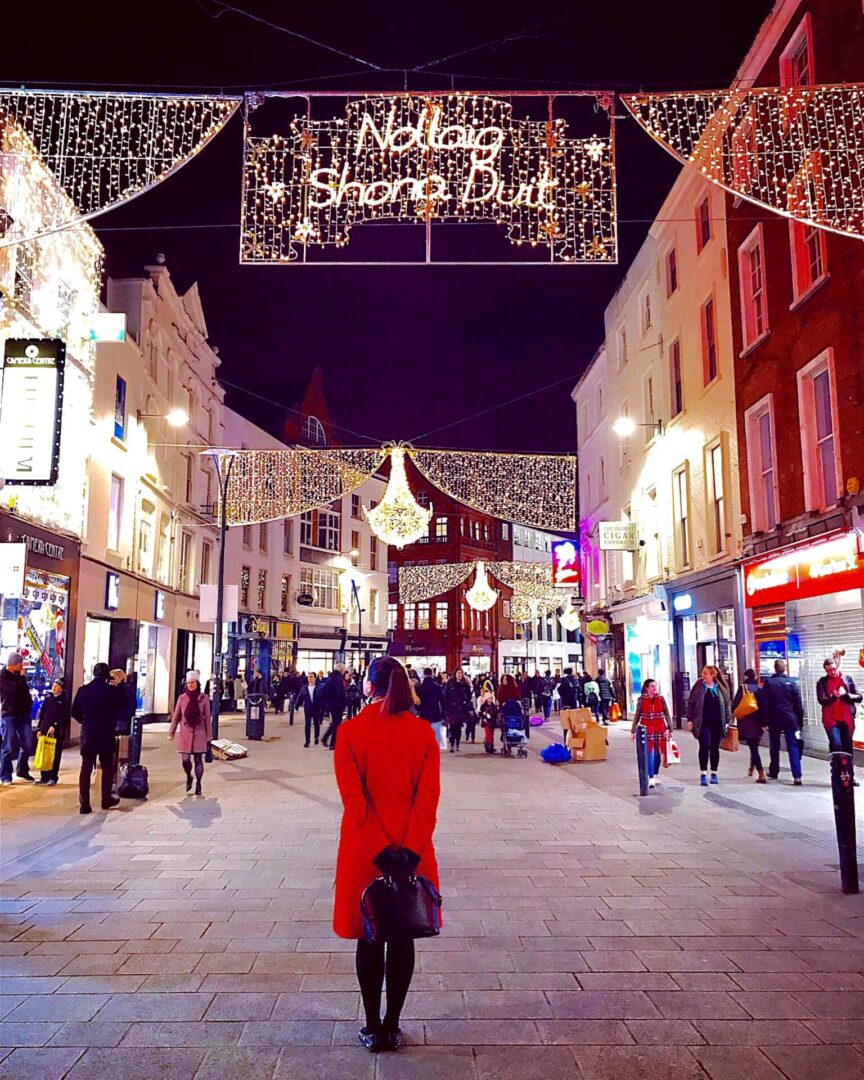 Grafton street pedestrian walking mall at night time lit up by all the Christmas lights and decorations wishing you Nollaig Shona Duit