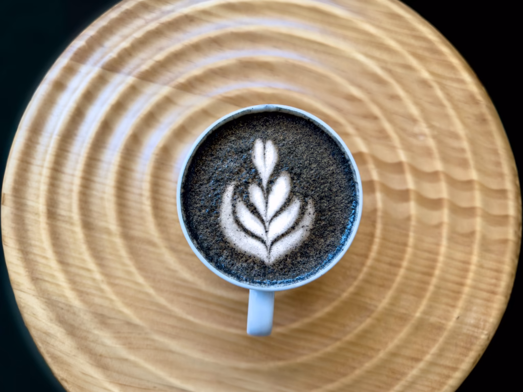 Close-up of expertly crafted espresso latte art prepared by a barista at Highwheeler Coffee in Central New York.