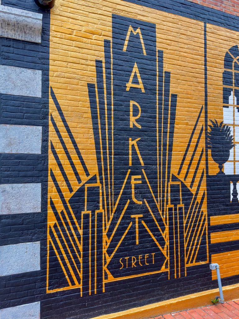 Vibrant local street art mural in Water Street Square near Riverwalk Coffee Roasters in Oswego, New York.