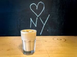 A glass of coffee with the word " new york " written on it.