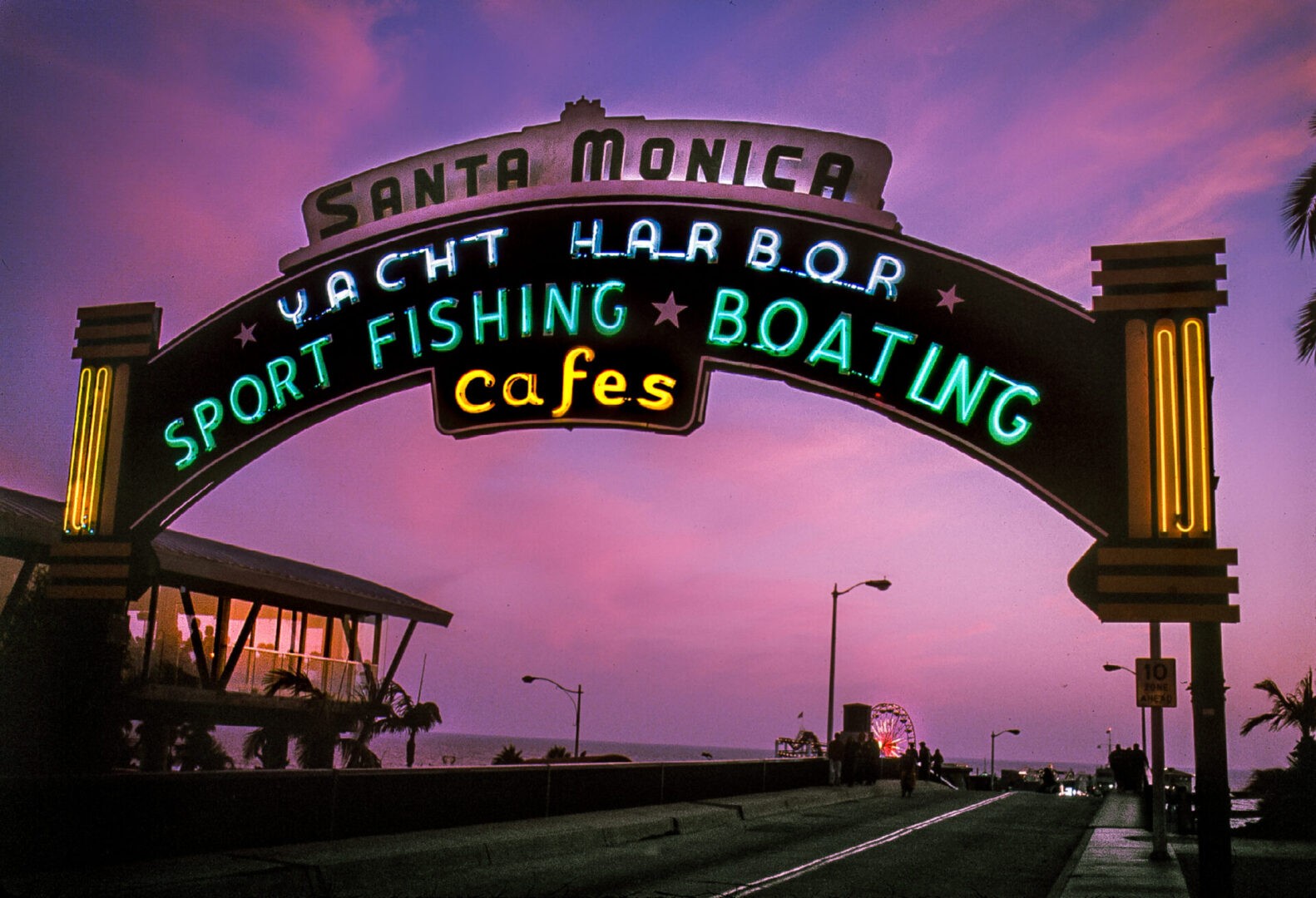 Final stop in Route 66 Start to Finish, the Santa Monica Pier at dusk with the neon sign welcoming you to the pier.