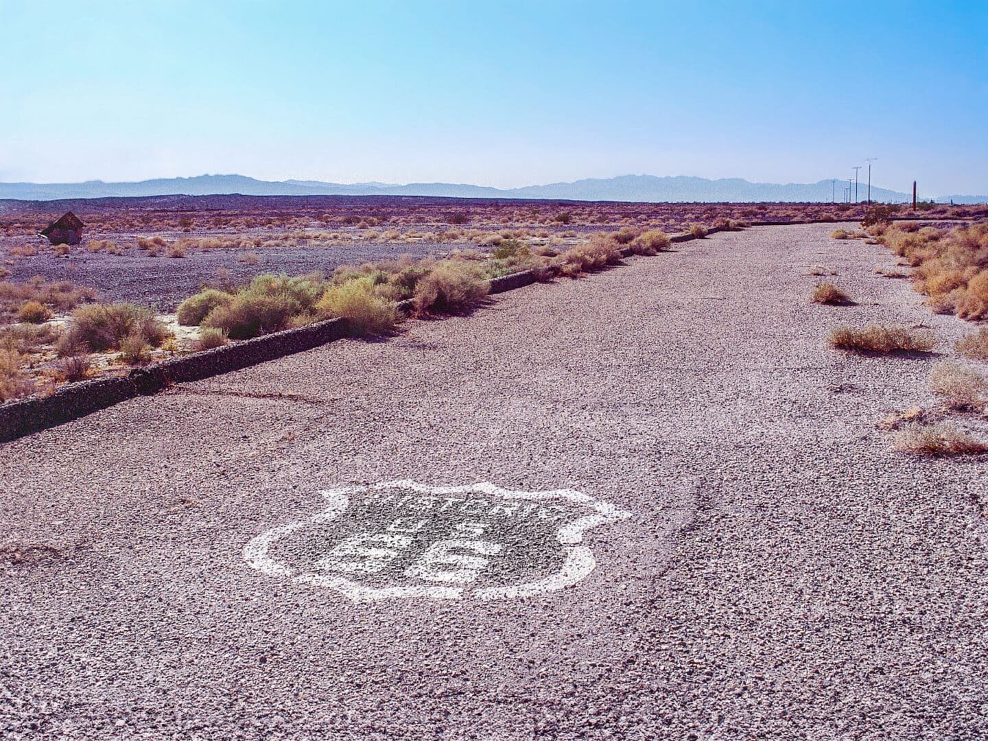 Route 66 - Amboy, California Original Historic Route 66 roadway in the Mojave Desert with Route 66 shield painted on the road