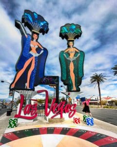 Two 50 foot illuminated Showgirls pose over a colourful plaza complete with larger-than-life poker chips and dice, welcoming you to the City of Las Vegas.