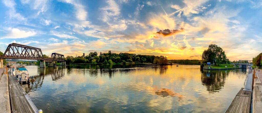 A body of water with trees and clouds in the sky. The Erie Canal canalway should be on everyones travel bucket list, especially for boating, sunsets and fishing