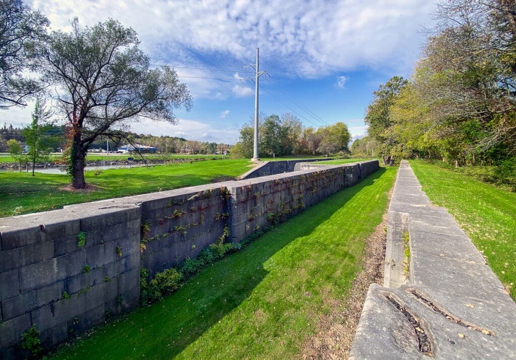 Large stone walls are the remains of historic Lock 60 of the historic Eric Canal, next to today's canalway. © Spotlight Sojourns