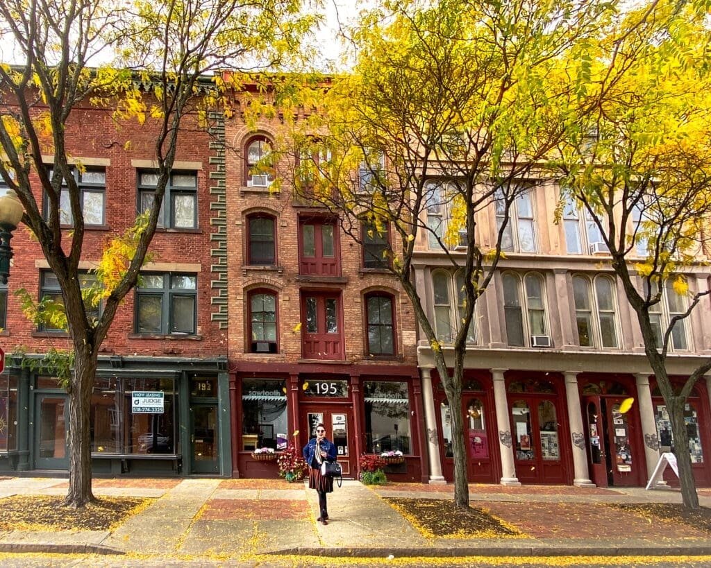 The Erie canalway has wonderful historic cities along every mile, like Troy, New York, with its historic downtown buildings, pictured here during fall with the trees turning leaves.