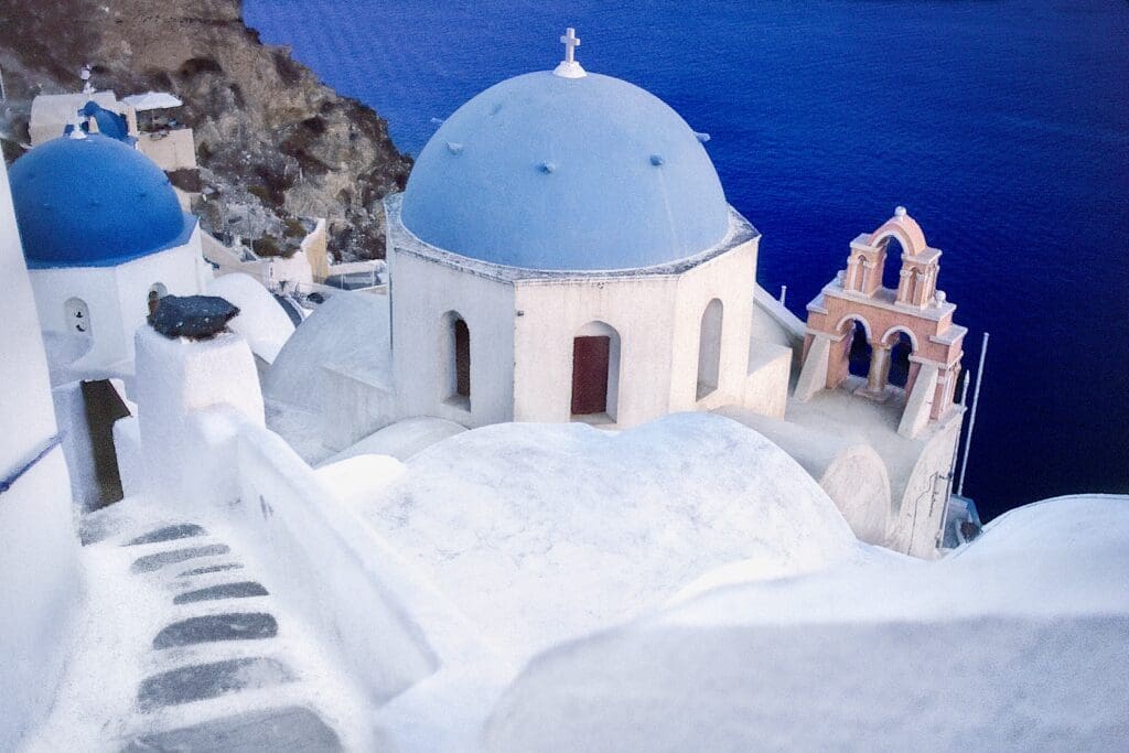 White cube architecture toped with blue domes in Oia Santorini is an iconic image