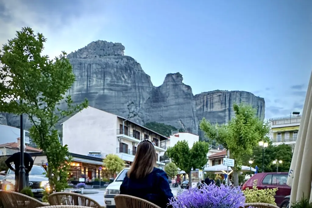 Evening time sitting at at cafe in the main square gazing up at the monolithic stones of the unique landmark of Meteora