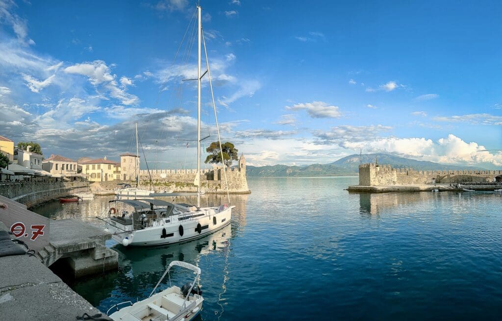 A harbor with boats and a castle in the background.