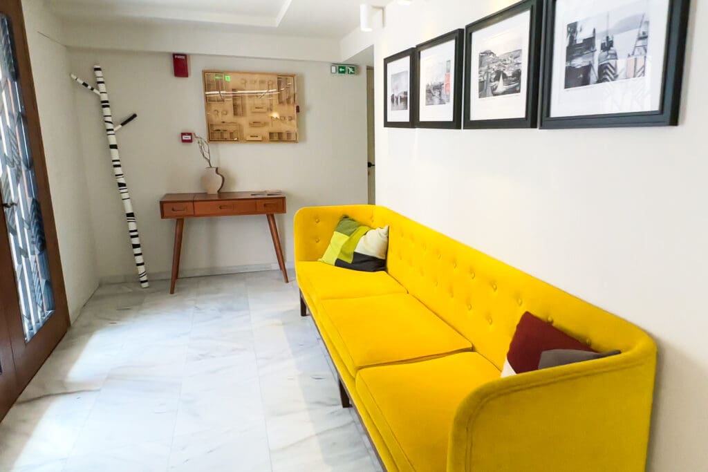 Iconic yellow couch and black and white photographs in the Lobby of this Hotel in Nafpaktos