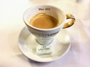 A cup of coffee on top of a saucer. Melange coffee in a Traditional Viennese Coffee House in Vienna Austria
