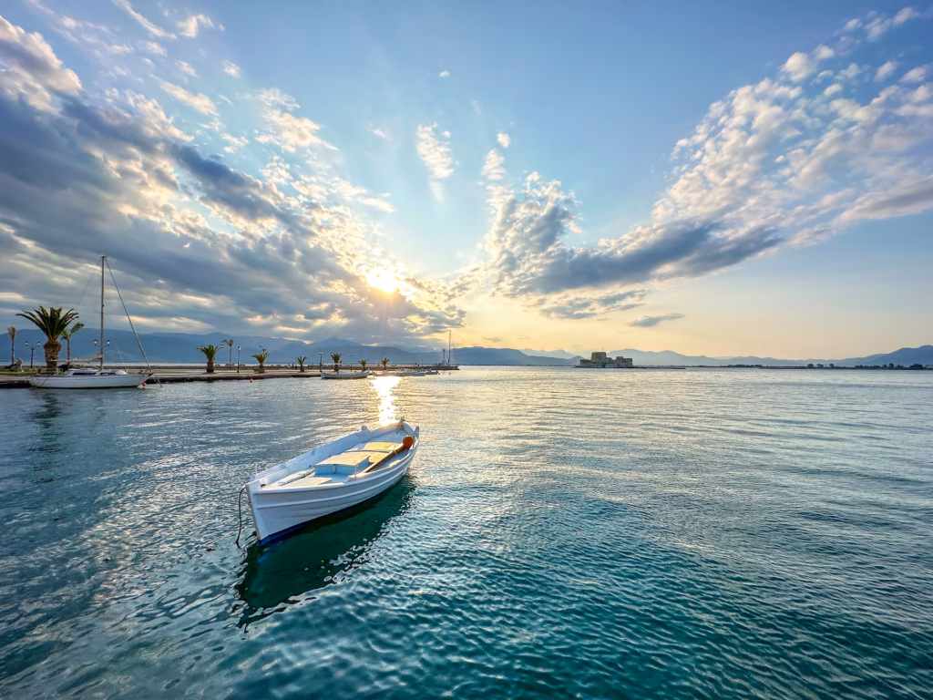 A boat floating on top of the ocean under cloudy skies.