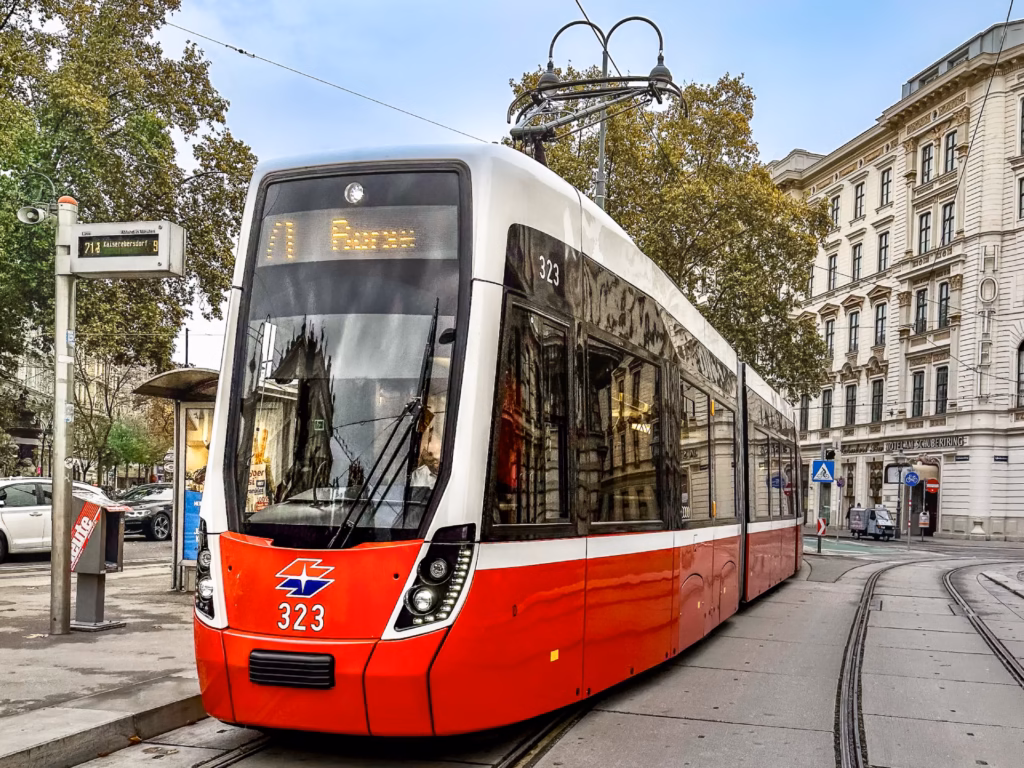 A red and white tram is on the street