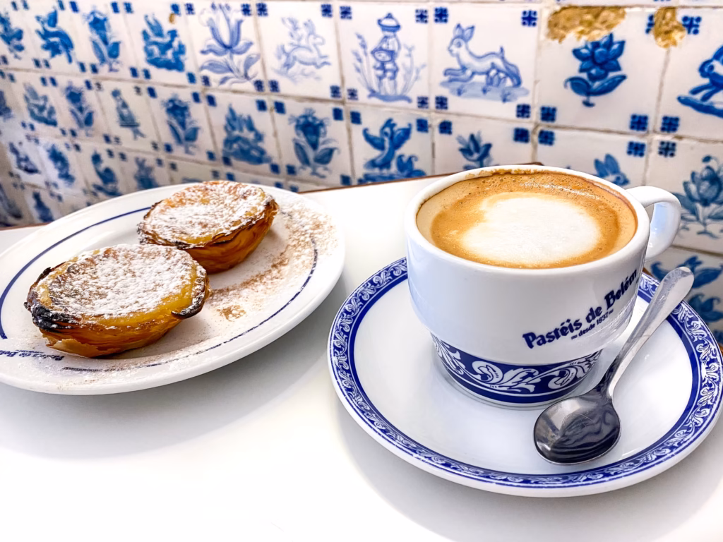 A cup of coffee and two pastries on plates.