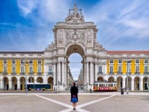 A person standing in front of an arch.