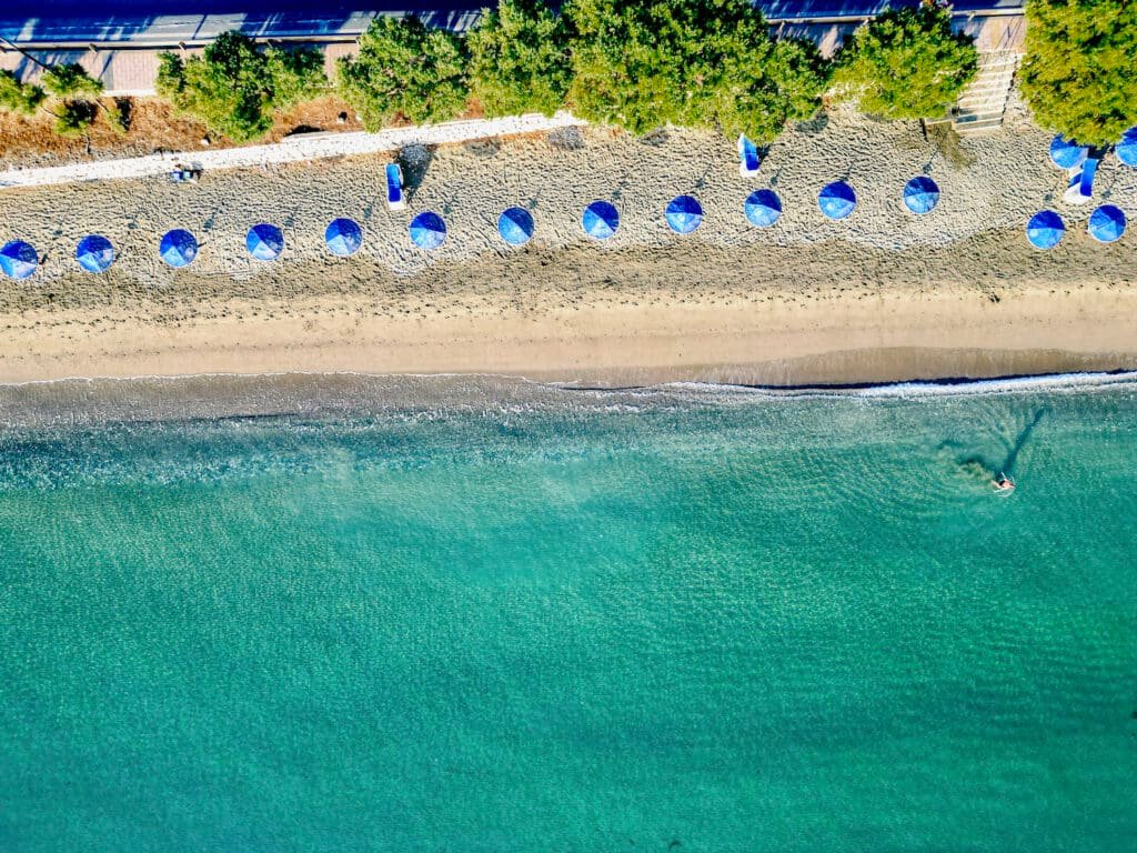 Sandy beaches, blue umbrellas and turquoise clear water attract many visitors to Greece every year. Photo © Spotlight Sojourns