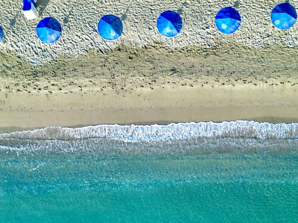 Sandy beaches, blue umbrellas and turquoise clear water attract many visitors to Greece every year. Photo © Spotlight Sojourns