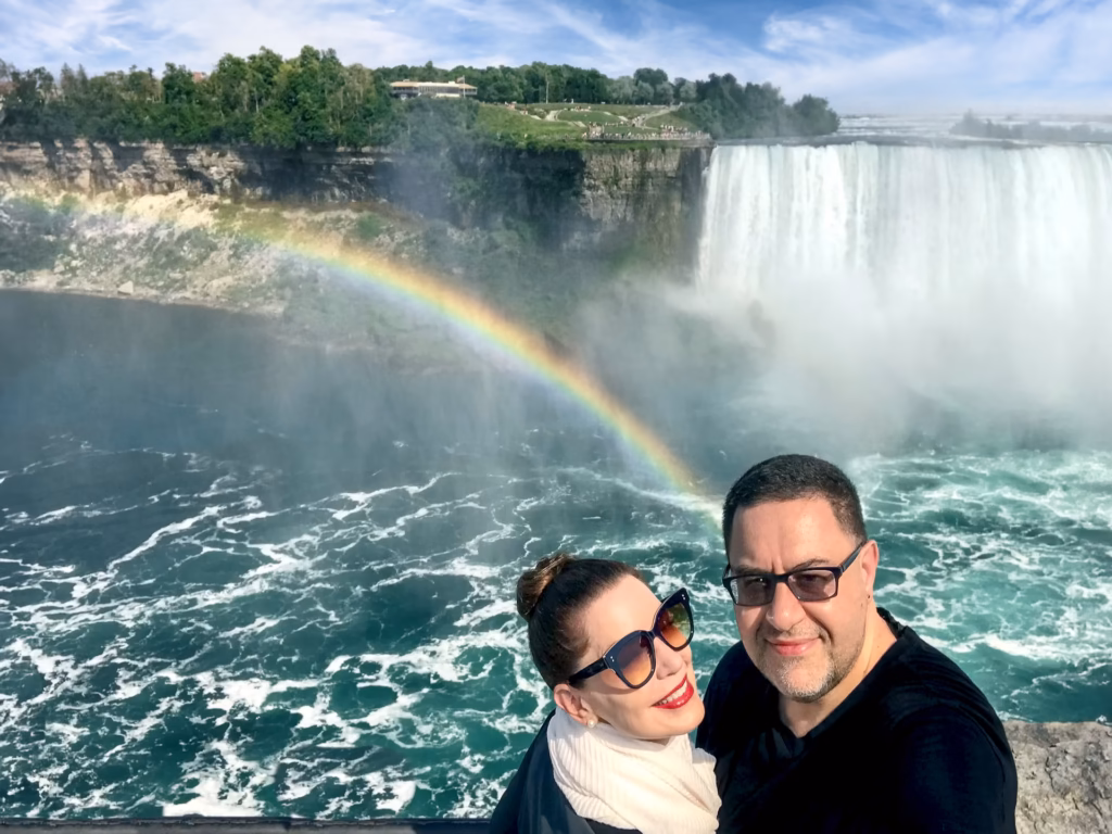 Honeymoon capital of the world: Marilee and Paul Kostadimas in Niagara Falls, Canada, overlooking Goat Island and the Horseshoe Falls in Niagara Falls, New York. A rainbow rises from the Niagara River.