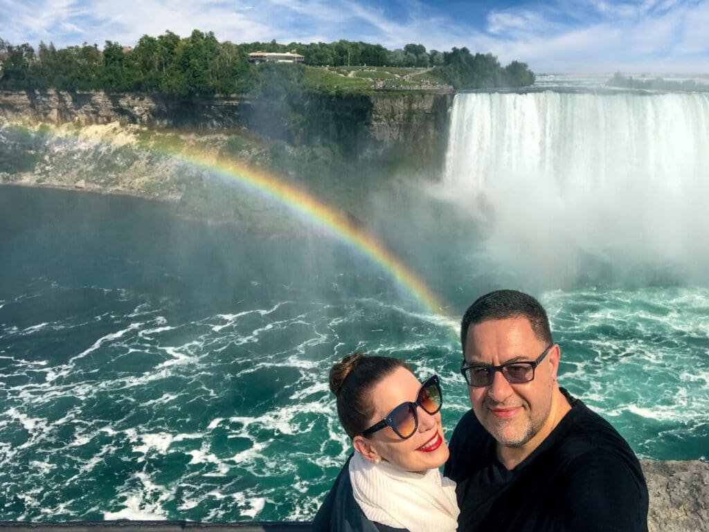 Honeymoon capital of the world: Marilee and Paul Kostadimas in Niagara Falls, Canada, overlooking Goat Island and the Horseshoe Falls in Niagara Falls, New York. A rainbow rises from the Niagara River.