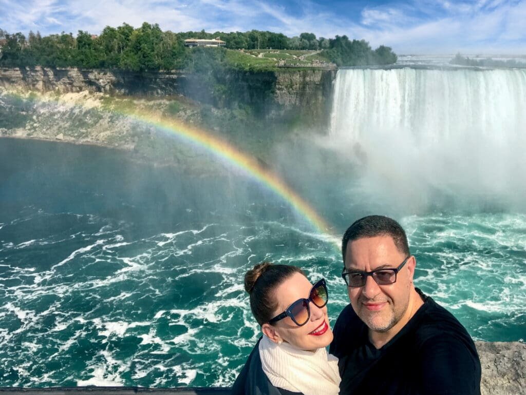 Honeymoon capital of the world: Marilee and Paul Kostadimas in Niagara Falls, Canada, overlooking Goat Island and the Horseshoe Falls in Niagara Falls, New York. A rainbow rises from the Niagara River.