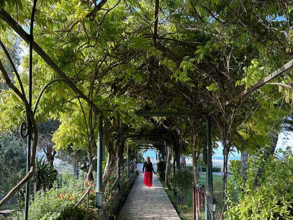 Strolling through a plant covered walkway in the Achilleion Palace Imperial Gardens 