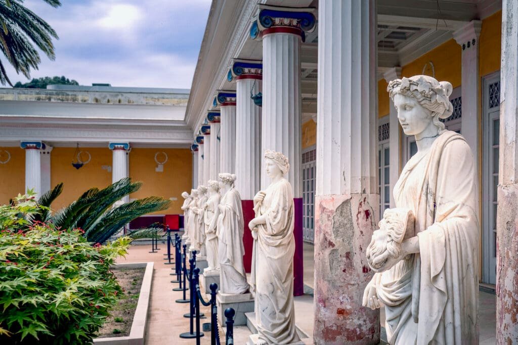 Row of classical Greek statues of the muses in the courtyard of the Achilleion Palace