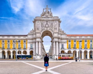 A person standing in front of an arch.