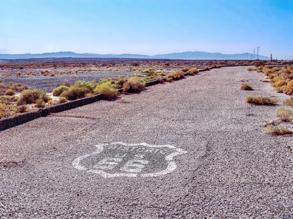 Original Historic Route 66 roadway in the Mojave Desert with Route 66 shield painted on the road