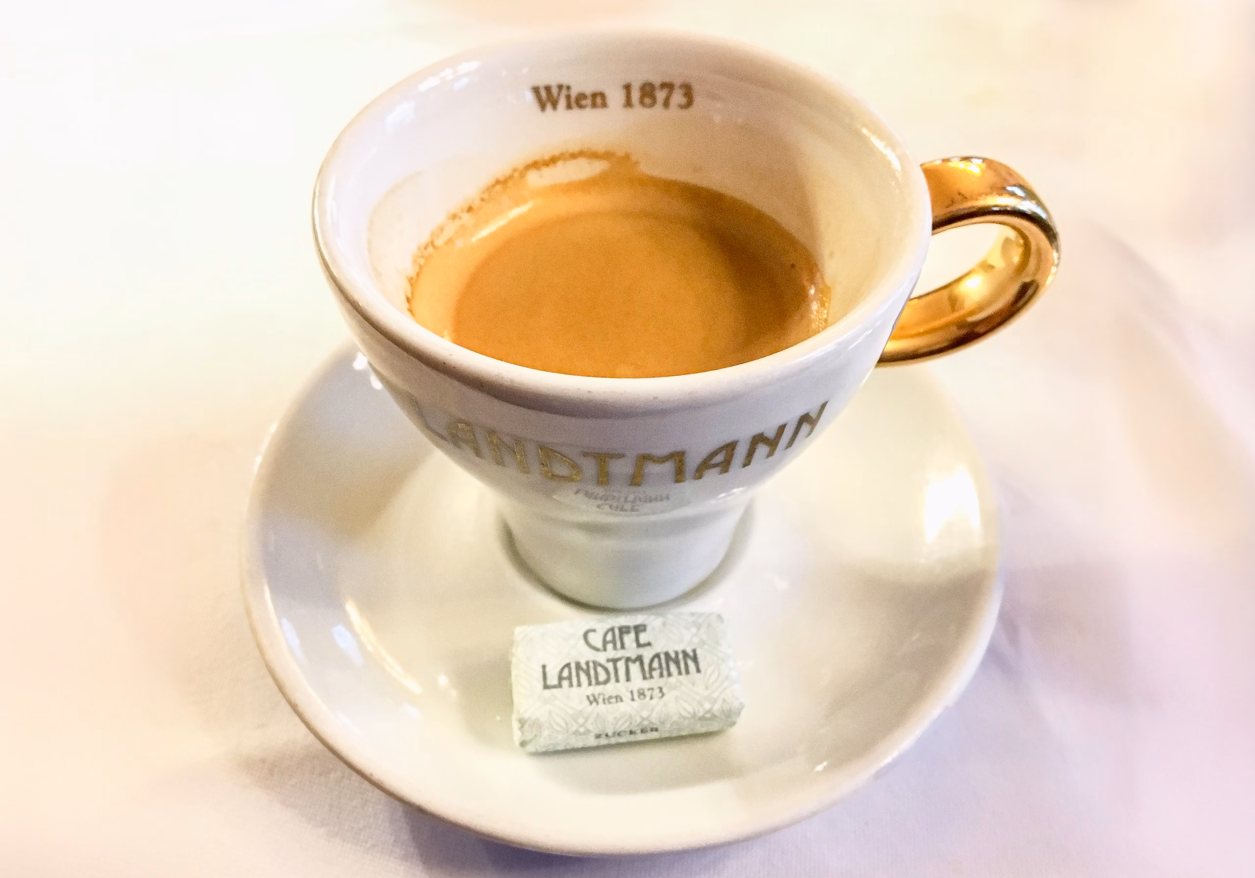 A cup of coffee on top of a saucer. Melange coffee in a Traditional Viennese Coffee House in Vienna Austria